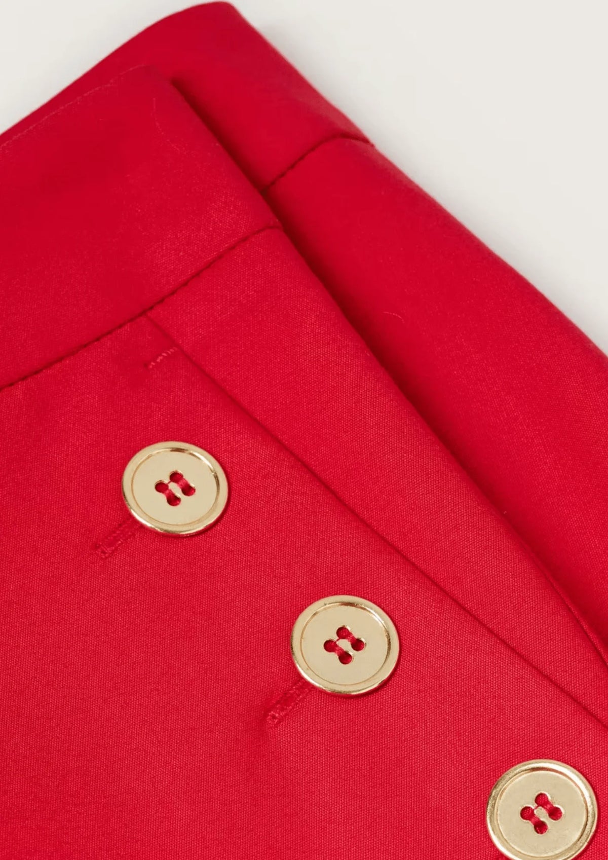 Pantalon à bouton rouge coupé